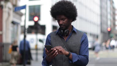 Portrait of African American male outdoors with smartphone