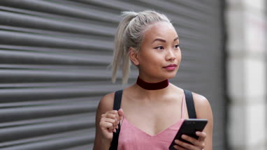 Young adult female using smartphone on street