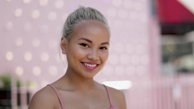 Portrait of young adult female with pink background