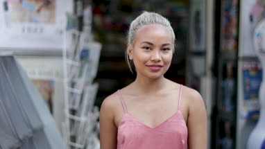 Portrait of young adult female at newsagents