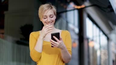 Young adult female laughing at smartphone