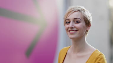 Portrait of young adult female with arrow sign in background