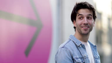 Young adult male with arrow sign in background