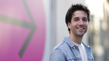 Portrait of young adult male with arrow sign in background