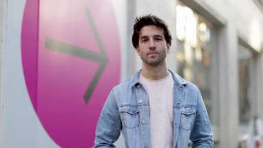 Portrait of young adult male with arrow sign in background