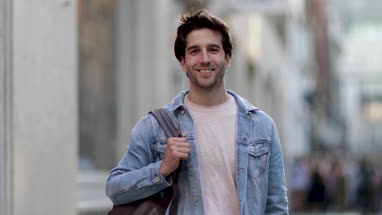 Young adult male walking down street