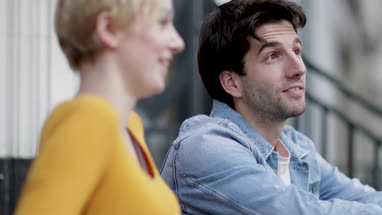 Friends talking outdoors sitting on steps