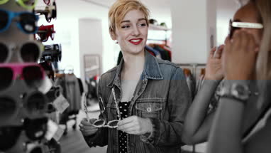 Millennials trying on sunglasses in a vintage store