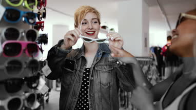 Millennials trying on sunglasses in a vintage store