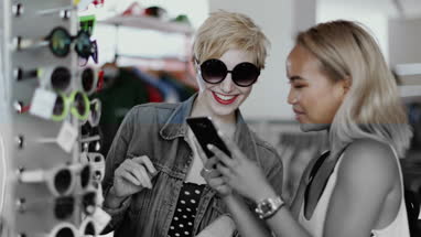 Millennials looking at smartphone in a vintage store