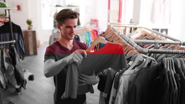 Young adult male clothes shopping