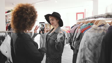 Millennial trying on a hat in a vintage clothing store