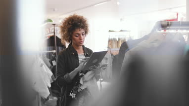 Store manager using digital tablet in a clothing store