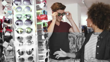 Millennials trying on sunglasses in a vintage store