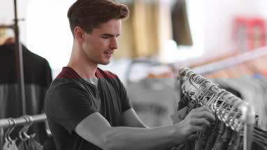 Young adult male clothes shopping
