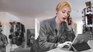 Store manager using digital tablet in a clothing store