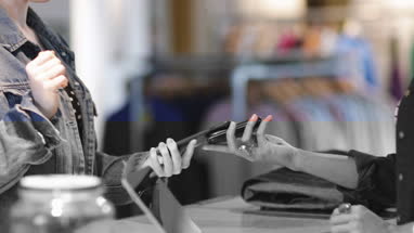 Closeup of customer paying with smartphone at checkout