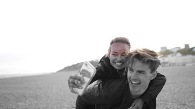 Excited friends on the beach taking a selfie