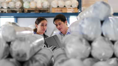 Manager training new employee in a packing warehouse