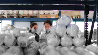 Manager training new employee in a packing warehouse