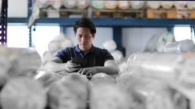 Male scanning item in distribution warehouse