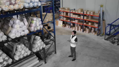 Overhead shot of male working in distribution warehouse with digital tablet