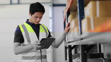 Male working in distribution warehouse with digital tablet