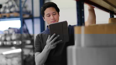 Male working in distribution warehouse with digital tablet
