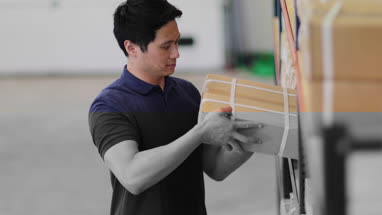 Male picking up box from shelf in distribution warehouse