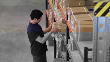 Overhead shot of male picking up box from shelf in distribution warehouse
