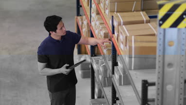 Overhead shot of male working in distribution warehouse with digital tablet