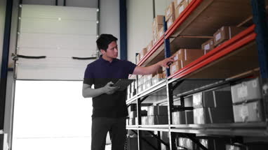 Male working in distribution warehouse with digital tablet