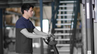 Male working in warehouse using forklift truck