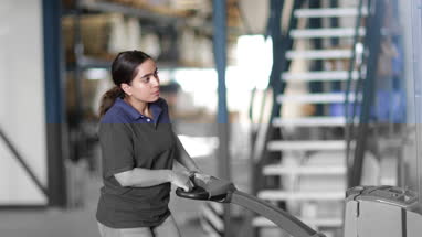 Female working in warehouse using forklift truck