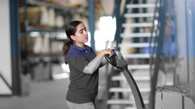 Female working in warehouse using forklift truck