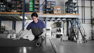 Male cutting fabric in a manufacturing warehouse