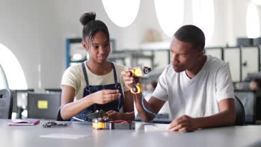 High school students working on a robotic arm in class