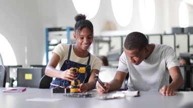 High school students working on a robotic arm in class
