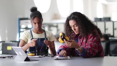 High school students working on a robotic arm in class