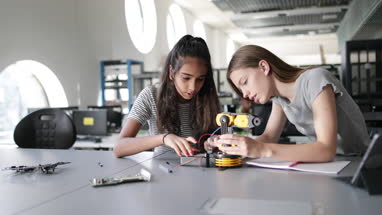 High school students working on a robotic arm in class