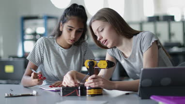 High school students working on a robotic arm in class