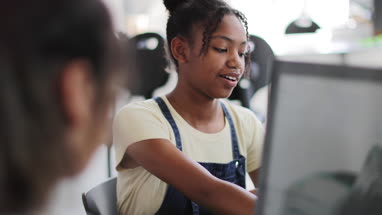 Closeup teenage girl using a computer in class