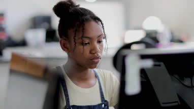 Closeup teenage girl using a computer in class