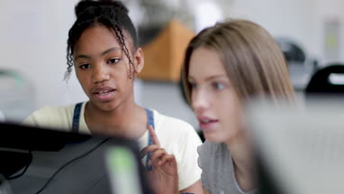 Closeup teenage girls using a computer in class
