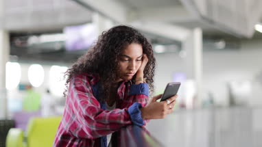 Female student looking at smartphone in high school