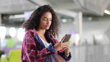 Female student looking at smartphone in high school
