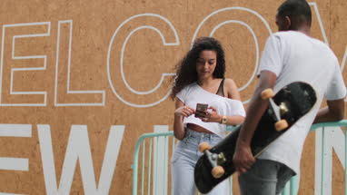 Teenagers socialising outdoors in city with smartphone