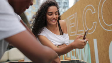 Teenagers socialising outdoors in city with smartphone