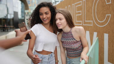 Teenagers socialising outdoors in city looking at smartphone