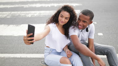 Teenage boyfriend and girlfriend taking a selfie